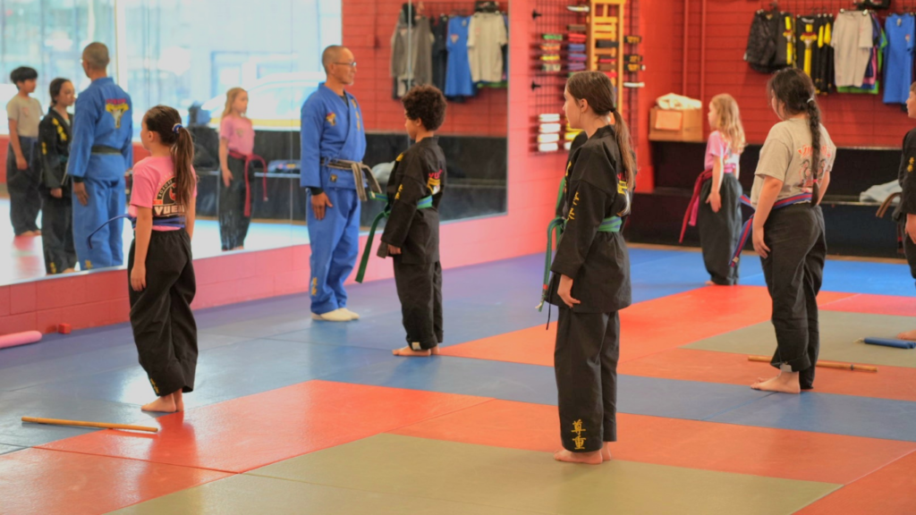 Martial arts students standing in a respectful line-up during a class at Yuen's Family Martial Arts.