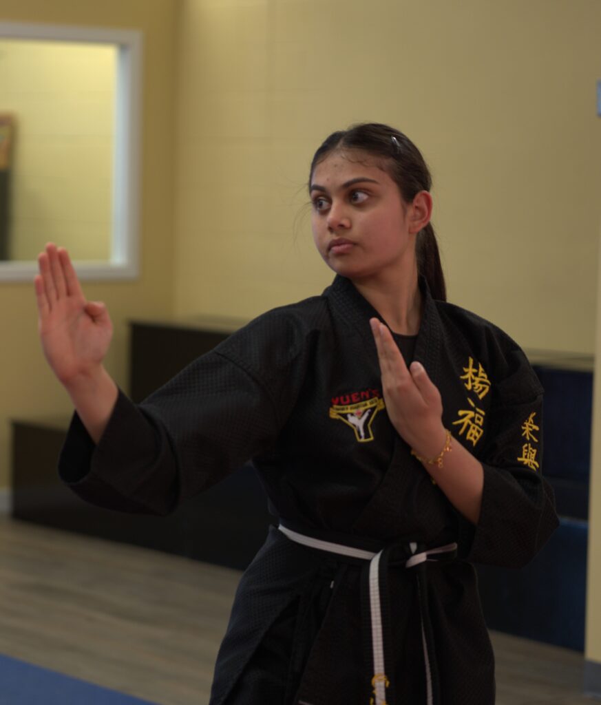 A female martial arts student practicing a traditional knife-hand block at Yuen's Family Martial Arts in Coquitlam